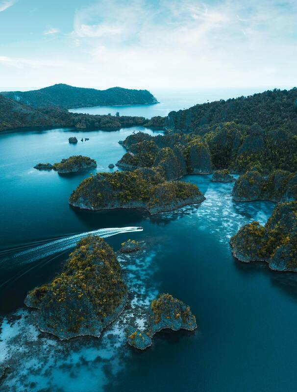Emerald waters of Halong Bay with dramatic limestone karst formations and traditional wooden boats